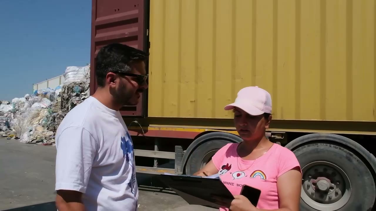 Geri dönüşüm sahasında plastik balyaları taşıyan yükleyici